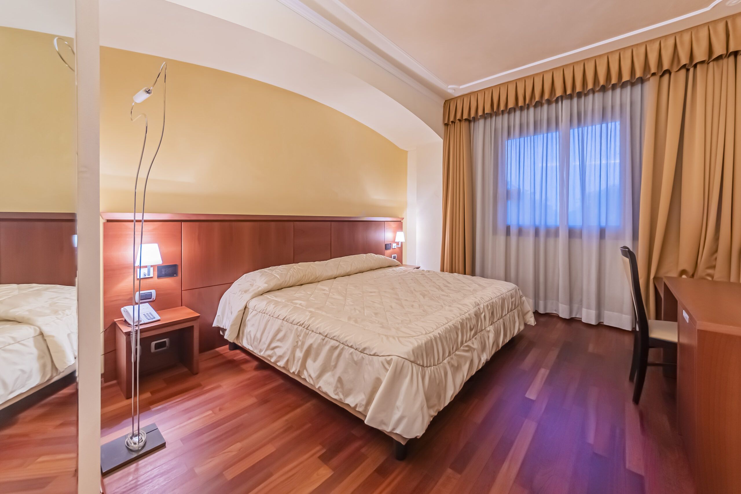 Double bed in a Suite room at Century Hotel Parma, with wooden flooring and modern furnishings – 4-star comfort